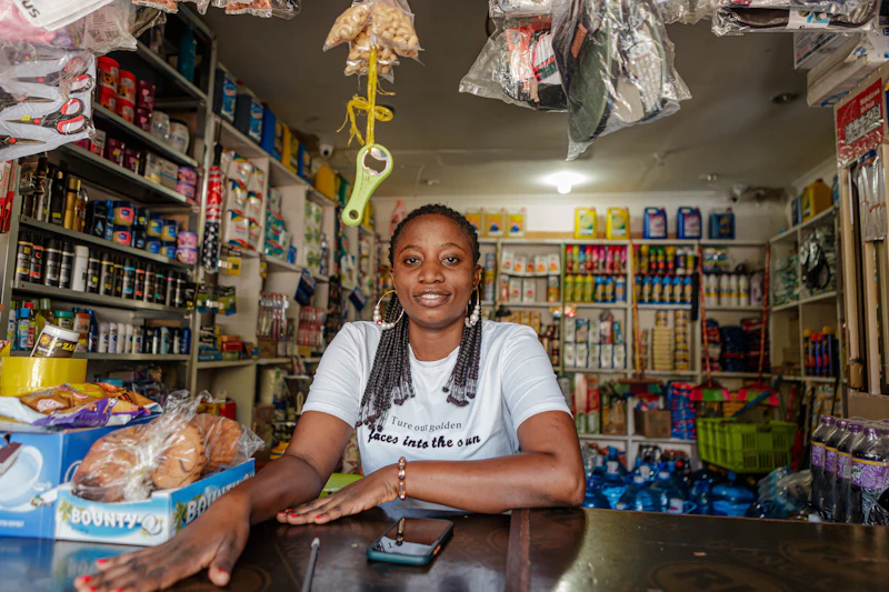 A smiling shop owner behind the counter